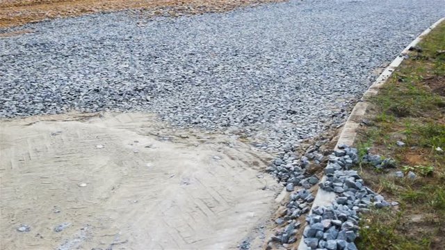 Road construction: sand and rubble scattered on the future roadway. Real time, General plan, day, summer