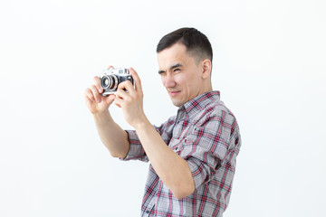 Technologies, photographing and people concept - handsome asian young man with retro camera over...