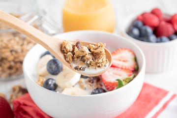 granola and milk in wooden spoon