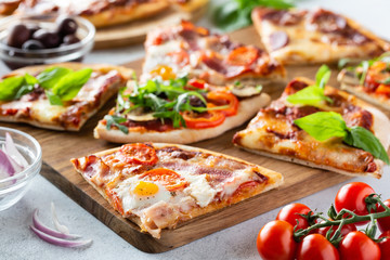 Top view of slices fresh different pizza on a light background. Pizza on the table.