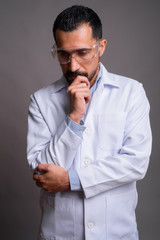 Handsome bearded Persian man doctor wearing protective glasses a