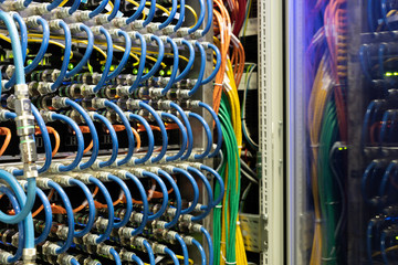 Close-up of modern supercomputer equipment with optic cables and hubs in server room, copy space