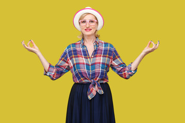 Portrait of calm modern stylish mature woman in casual style with hat and eyeglasses standing with...