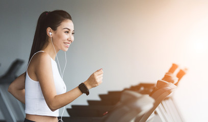 Working out in health club. Fit woman running on treadmill