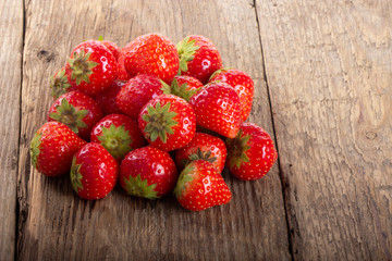 heap of strawberries on wooden background. top view
