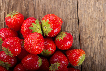 heap of strawberries on wooden background. top view