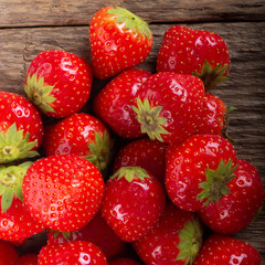 heap of strawberries on wooden background. top view