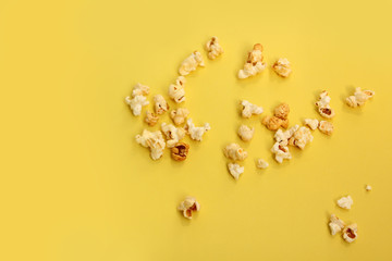 fragrant popcorn scattered on a yellow background, copy space