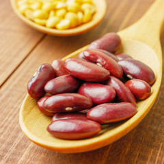 Close up red beans in wooden spoon on wooden table
