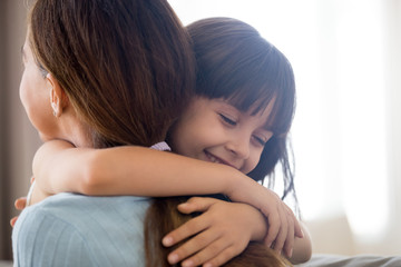 Cute little girl hug young mom showing love and care