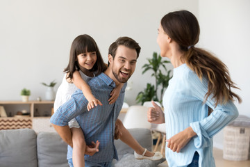 Playful parents have fun playing with preschooler daughter