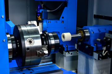 Fragment of the detail in the chuck of an industrial modern machine during grinding. Small depth of field. Shooting in real conditions of work of the industrial machine