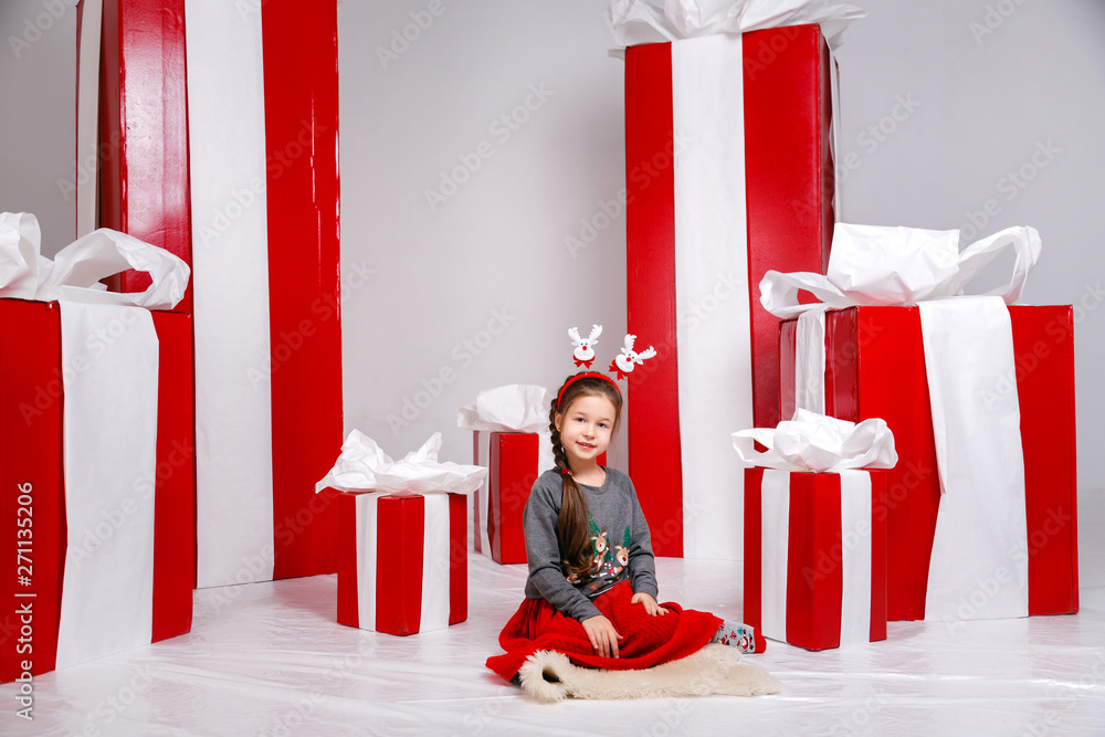 Wall mural Funny little girl in the New Year's image, showing different emotions. Photo taken in studio