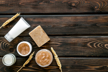 Cosmetics with natural herbal and wheat ingredients on wooden background top view copyspace