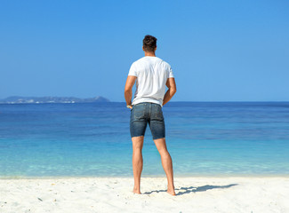 Fototapeta na wymiar Handsome, muscular man relaxing on a tropical beach