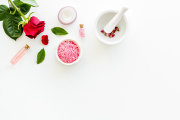 Cream, bath salt, lotion for organic cosmetics with rose flower on white background top view space for text