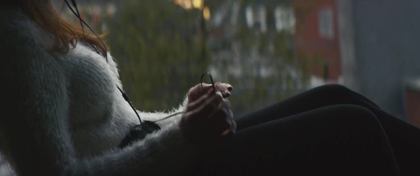 Dreamy relaxed woman listening music at home