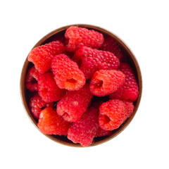 heap of red raspberries in wooden cup isoalted on white background. top view