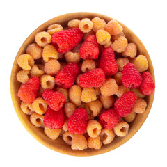 yellow and red raspberries in wooden plate isolated on white background. top view