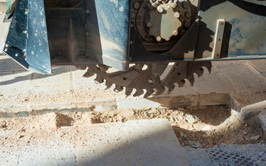 wreath with cones for drilling rock mounted on mini excavator during the execution of a mini-trench