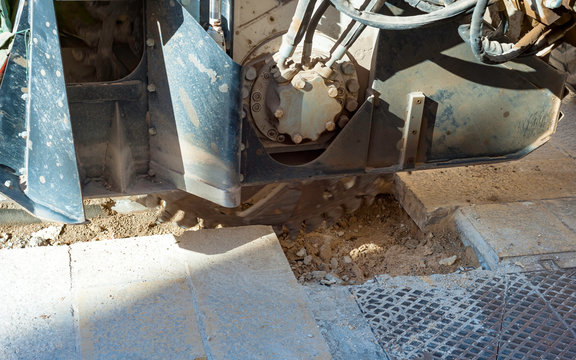 wreath with cones for drilling rock mounted on mini excavator during the execution of a mini-trench