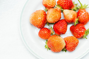 Strawberries on a white background, fresh, tasty and natural strawberries from grandfather's garden on a white plate