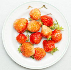 Strawberries on a white background, fresh, tasty and natural strawberries from grandfather's garden on a white plate