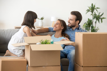 Happy parents have fun with child relaxing on moving day