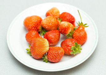Strawberries on a white background, fresh, tasty and natural strawberries from grandfather's garden on a white plate