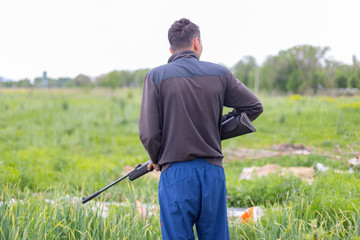 Young man shoots air rifle in nature