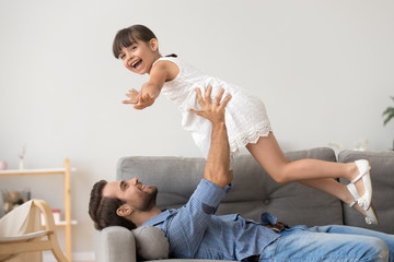 Obraz premium Happy dad relax with cute daughter playing game