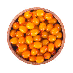 heap of sea buckthorn in wooden cup isolated. top view