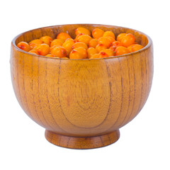 heap of sea buckthorn in wooden cup isolated