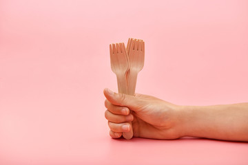 Disposable wooden cutlery forks in hand. The concept of environmental protection, zero waste