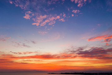 Naklejka na ściany i meble Himmel eines Sonnenunterganges über dem Meer mit roten Farbtönen