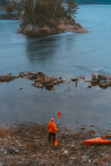 The guy is standing at the frozen lake