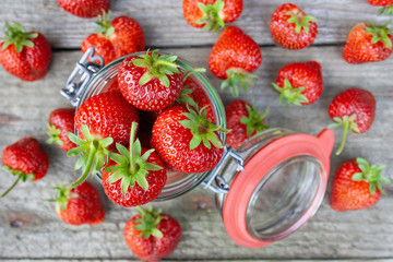  A jar filled with red, ripe strawberries