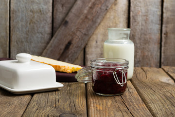 breakfast, cherry jam, milk bottle, slice of bread, old wood table