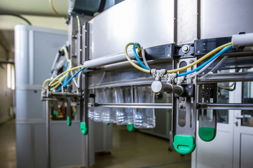 Industrial automated machine for blowing plastic bottles from PET preforms, conveyor belt in plant