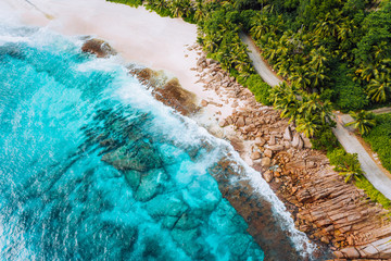 Aerial photo of ocean waves hitting rocky coastline of beautiful paradise dream tropical beach at Seychelles. Summer vacation, travel and lifestyle concept - obrazy, fototapety, plakaty