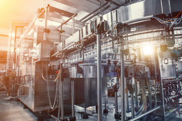 Empty plastic bottles move on automatic conveyor line or belt in water and juice factory or plant production.