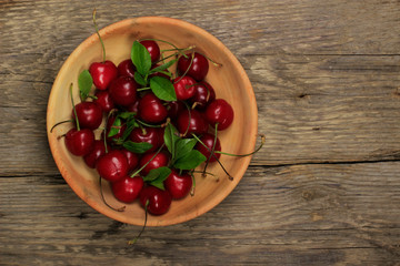cherry in wooden plate on wooden background
