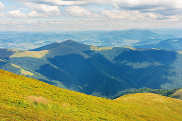 sunny summer landscape in mountains. beautiful scenery observed from the hill. clouds on a blue sky.