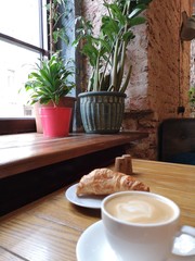 Breakfast in cafe, coffee and croissant