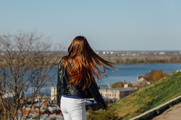 Attractive young woman in urban background wearing black leather jacket.