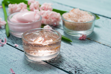 cosmetic creams with pink hyacinth flowers, on old cracked blue table