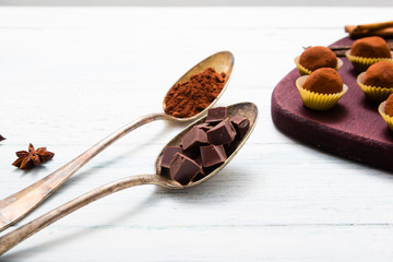chocolate truffles, cocoa powder, broken dark chocolate on white wooden