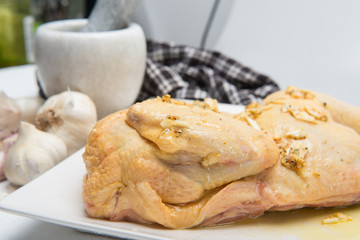 A piece of chicken in a plate with garlic