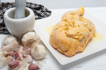 A piece of chicken in a plate with garlic