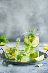 Fresh cool lemon lime mint water in glasses on a tray. Detox, healthy food, fitness cocktail. Selective focus